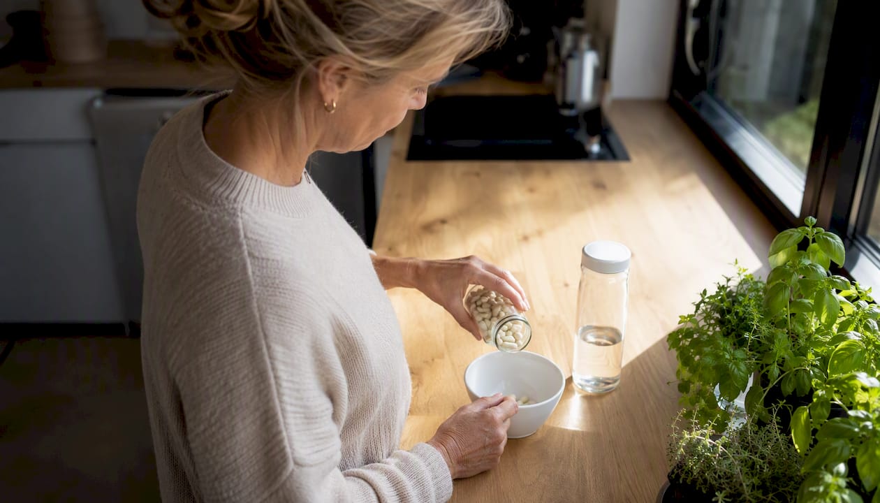 Hænder, der vejer kapsler med NMN kosttilskud